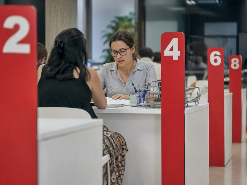 Empleado municipal atendiendo a un ciudadano en una oficina